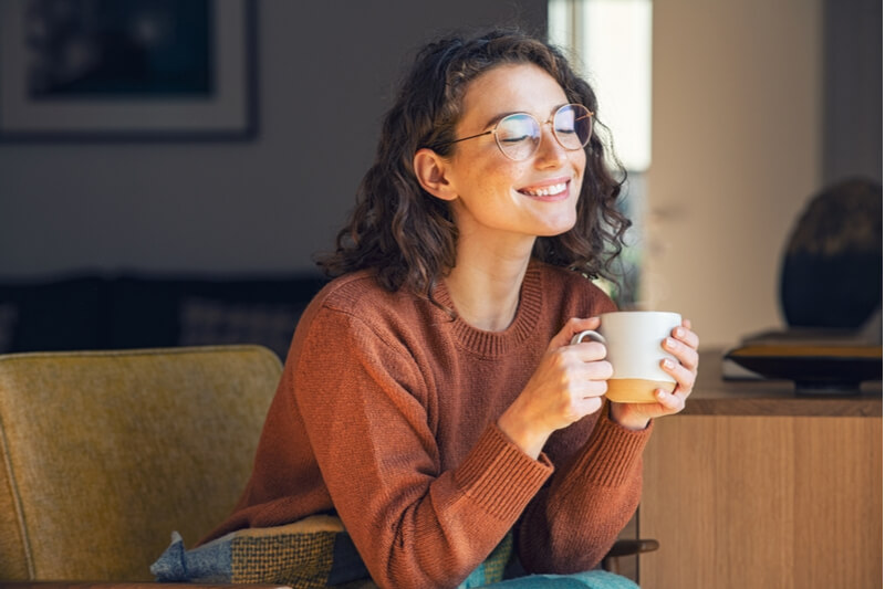 A young woman blissfully enjoys a cup of joe from one of the many San Juan Island Coffee Shops.