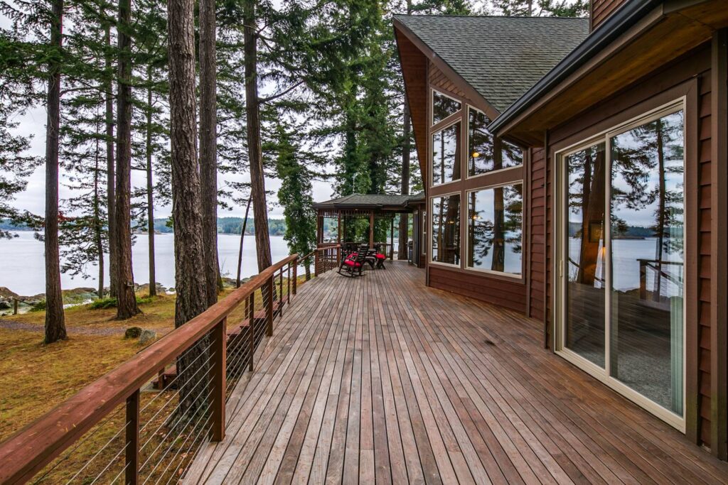 A long deck running alongside the exterior of a San Juan Islands waterfront vacation rental.